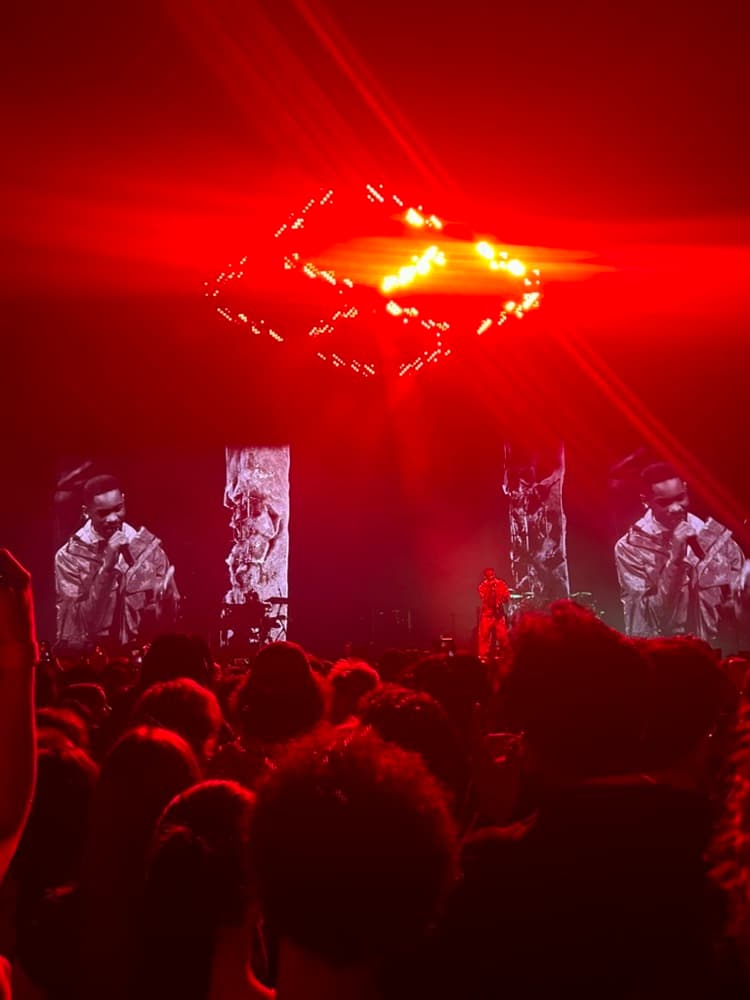 A crowd watching a set under red stage lights
